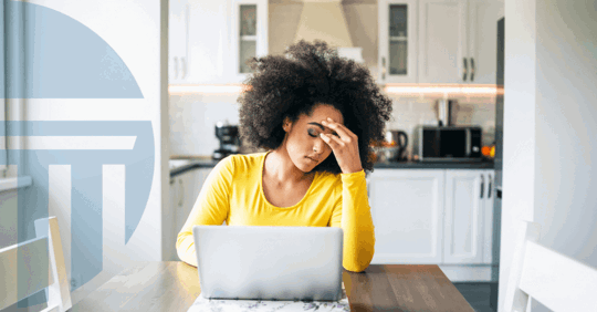 woman frowning with hands in face in front of computer