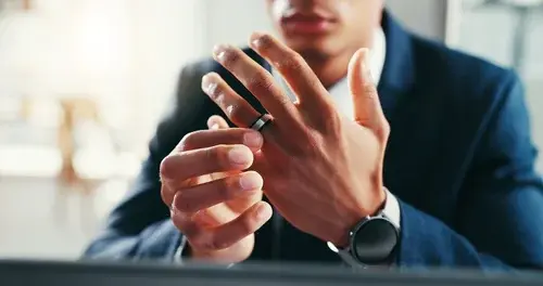 Wedding ring, hands and businessman in office for divorce with infidelity, breakup or toxic relationship. Mistake, anxiety and male person with marriage band for separation of commitment in workplace
