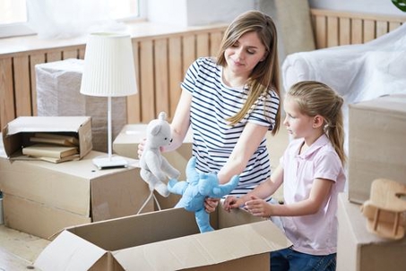 mom and daughter packing boxes